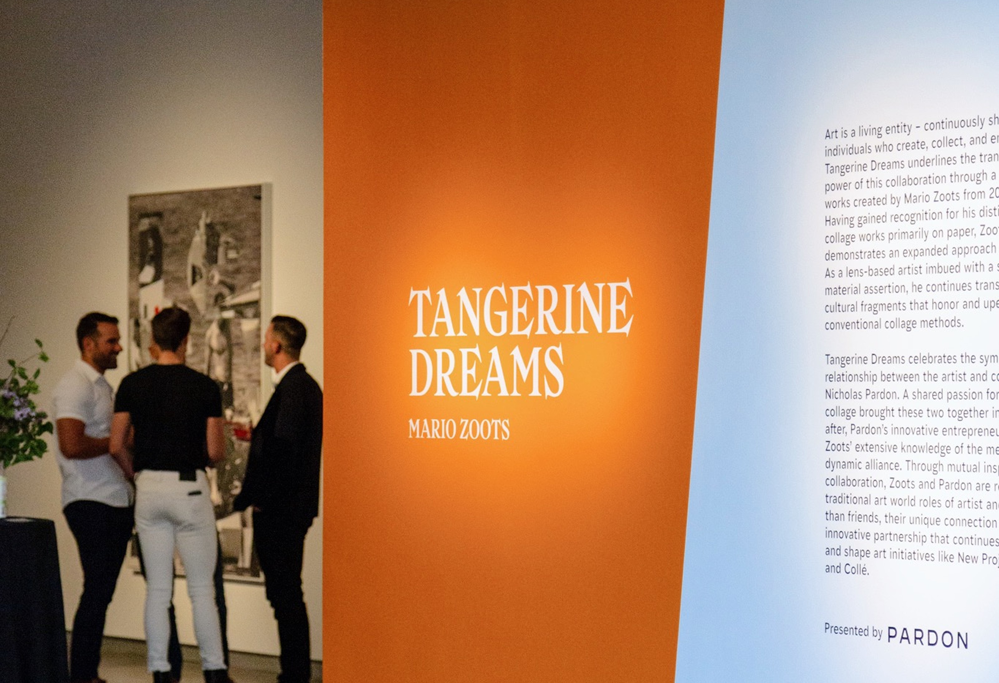 Tangerine Dreams exhibition installation — orange wall graphic with gallery visitors